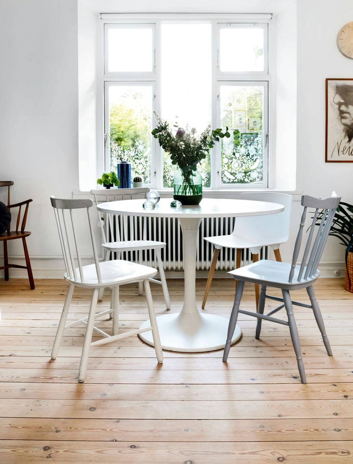 Blomsterkasse på vinduet Lys spisestue med tregulv og store vinduer